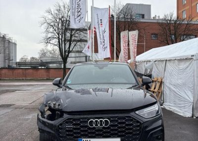 Nahaufnahme eines schwarzen Audi mit einem massiven Frontschaden in der Dr. Car Werkstatt Heilbronn, bereit für die Karosseriereparatur.