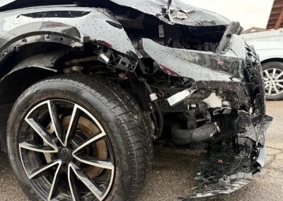 Seitliche Nahaufnahme des massiven Frontschadens an einem schwarzen Audi in der Dr. Car Werkstatt Heilbronn vor der Karosseriereparatur.