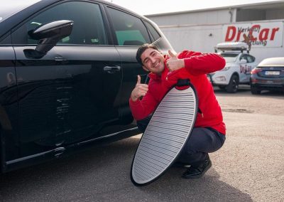 Experte von Dr. Car Heilbronn zeigt Daumen hoch neben einem Fahrzeug mit Dellen und nutzt einen PDR-Reflektor.