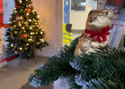 Einladender Eingangsbereich der Kfz-Werkstatt Dr. Car in Heilbronn mit Weihnachtsbaum und einem Schokoladenbären als Kundenpräsent.