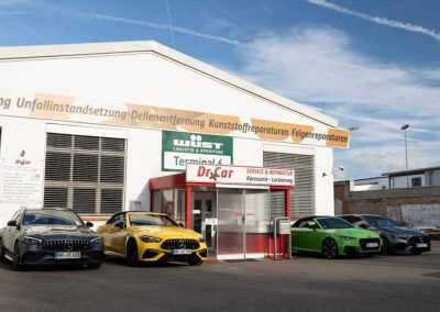 Außenansicht des Dr. Car Gebäudes mit mehreren hochwertigen Sportwagen (Mercedes, Audi) davor.