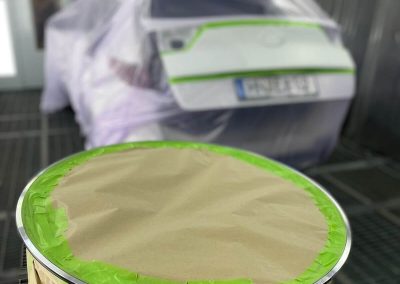 Eine für die Lackierung vorbereitete und präzise abgeklebte Felge in der Lackierkabine.