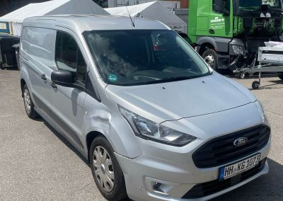 Silberner Ford mit Blechschaden am Kotflügel auf dem Gelände von Dr. Car Heilbronn vor der Unfallinstandsetzung.