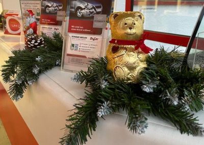 Kundenfreundlicher Empfangsbereich bei Dr. Car in Heilbronn mit ausliegendem Infomaterial zur Unfallinstandsetzung und saisonaler Weihnachtsdekoration (Glitzerstern).