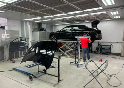 Ein erfahrener Kfz-Mechatroniker von Dr. Car Heilbronn repariert einen schwarzen Audi.