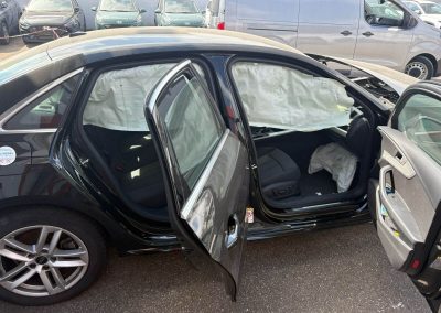 Dr. Car Heilbronn begutachtet einen Karosserieschaden eines silbernen VW Passat.