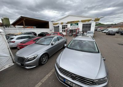 Übersicht über den Werkstatthof von Dr. Car in Heilbronn mit mehreren Kundenfahrzeugen, darunter Mercedes S-Klasse und VW, spezialisiert auf Lackierung und Instandsetzung.