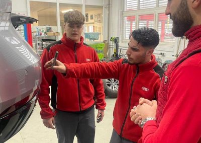 Das Team der Kfz-Lackiererei Dr. Car in Heilbronn bei der fachmännischen Vorbesprechung einer Karosserie-Instandsetzung an einem Fahrzeug.