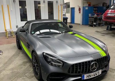 Matt grauer Mercedes-AMG GT S Supersportwagen mit neon-gelben Performance-Streifen und Akzenten, fotografiert in der Werkstatt von Dr. Car in Heilbronn.
