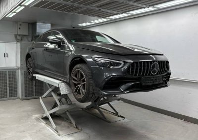 Ein schwarzes Mercedes-Benz steht auf einer Hebebühne in der modernen Kfz-Werkstatt Dr. Car in Heilbronn zur Inspektion und Reparatur unter professioneller Werkstattbeleuchtung.