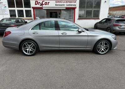 Seitenansicht eines Mercedes-Benz S-Klasse in Matt-Silber vor dem Dr. Car Service- & Reparaturzentrum für Karosserie und Lackierung in Heilbronn.