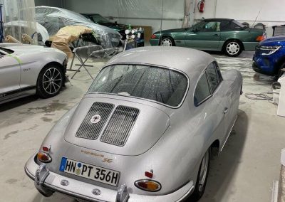 Ein klassischer silberner Porsche 356 Oldtimer steht in der modern ausgestatteten Werkstatt von Dr. Car in Heilbronn zur fachgerechten Aufbereitung.