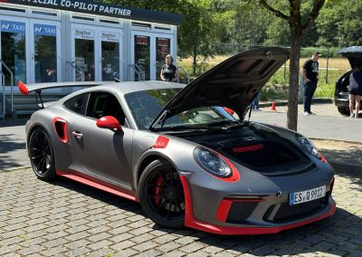 Frontansicht eines Porsche 911 GT3 RS in Matt-Grau mit roten Akzenten und geöffneter Haube, professionell aufbereitet von Dr. Car in Heilbronn.
