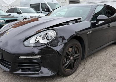 Schwarzer Porsche Panamera mit erheblichem Unfallschaden vorne links (Stoßstange, Kotflügel, Scheinwerfer) auf dem Gelände der Kfz-Werkstatt Dr. Car in Heilbronn zur Instandsetzung.