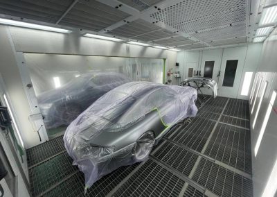 Präzises Lackieren eines silbernen Porsche in der modernen Lackierkabine von Dr. Car Heilbronn.