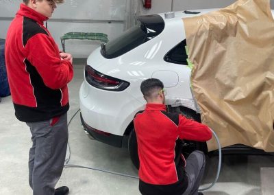 Zwei Fachkräfte der Kfz-Meisterwerkstatt Dr. Car in Heilbronn arbeiten gemeinsam an der Instandsetzung eines Fahrzeugs in der Werkstatt – Präzises Teamwork für optimale Ergebnisse.